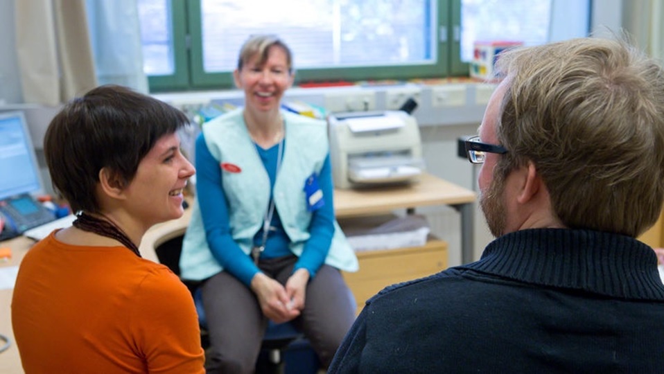 A man and woman are seeing a nurse at a health clinic.